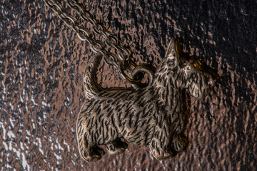 Terrier pendant on a silver chain on a shimmering backing