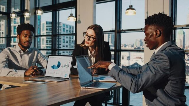 Business Professional Brainstorming Session: A diverse team of professional examines data and strategies in their laptops at a office brainstorming session - Powered by Adobe