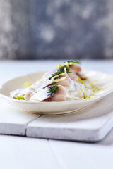 Herrings in mustard sauce. Bright wooden background.