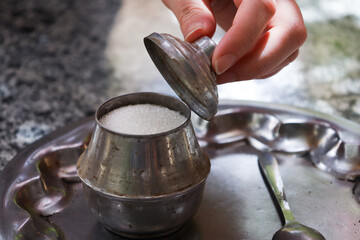 Hand Opening Metal Sugar Jar Lid to Reveal Granulated Sugar Inside
