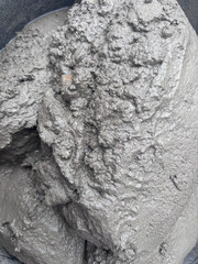 Image shows a close-up view of wet cement or concrete. The surface appears rough and textured, with...