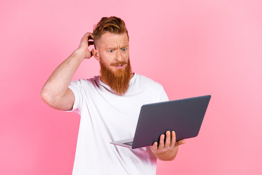 Confused man with a laptop against a pink background illustrating online troubleshooting or digital work challenges