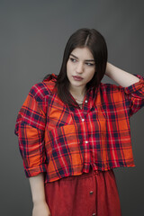 Plakat Stylish Woman in Red Maxi Skirt and Plaid Crop Top – Studio Fashion Portrait