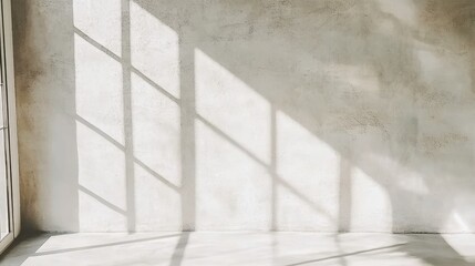 Obraz premium A large window casts a shadow on a wall. The room is empty and has a very plain appearance
