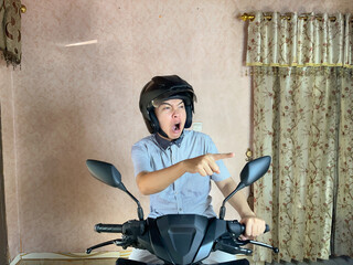 Asian man wearing motorcycle helmet with angry and upset expression 