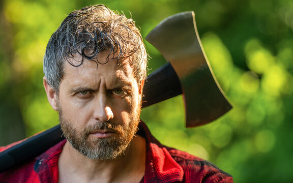 Hispanic lumberjack man face with axe. Lumberjack axe. Man with logging axe. Masculine brutal man portrait. Lumberjack outdoor portrait. Brutal lumberjack banner. Brutality and masculinity