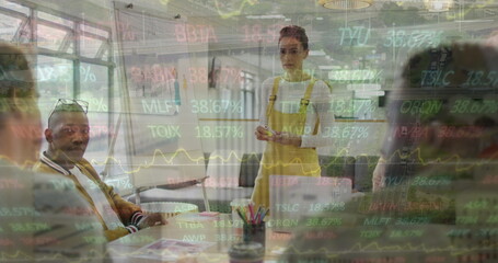 Obraz premium Image of financial data and graphs over diverse businesspeople in office