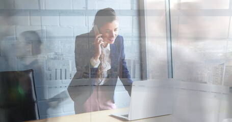 Image of caucasian businesswoman talking on cellphone over time lapse of blurred people