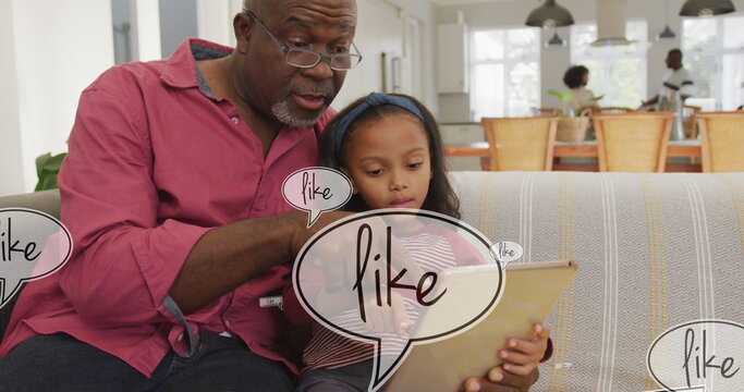 Image of like text over african american man and his granddaughter using tablet