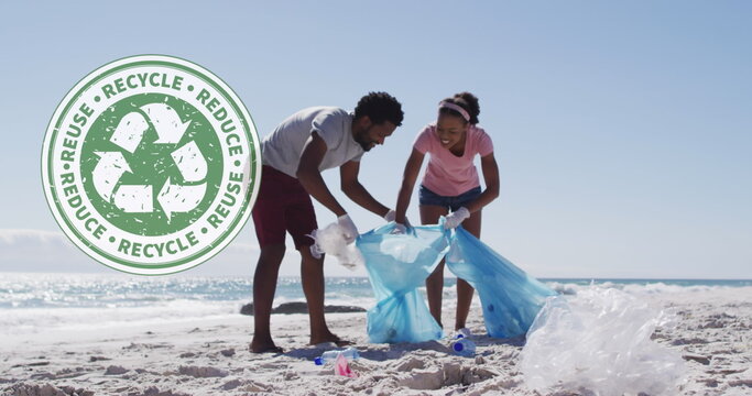 Image of recycling symbol over african american couple cleaning at beach - Powered by Adobe