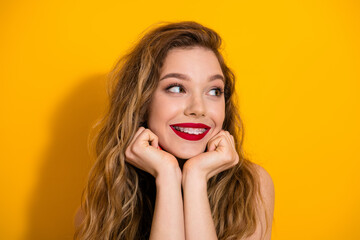 Smiling young woman posing joyfully against a vibrant yellow background exuding happiness and...