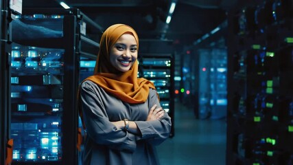 A smiling woman, possibly a technician, stands proudly with her arms crossed in a server room filled with advanced technology and data center equipment - Powered by Adobe