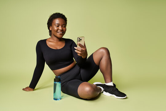Young woman enjoys a moment of relaxation during her workout session in a fitness studio