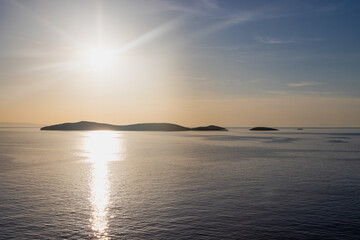 Fototapeta premium Blick von Andros aus auf die Inseln Syros und Kea sowie weiteren griechischen Kykladen-Inseln bei Sonnenuntergang