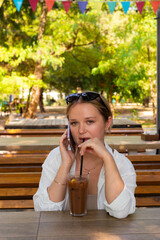 Pretty young girl wearing shorts and a white shirt in the summer park 