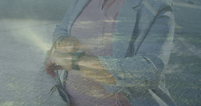 Image of clouds over african american businesswoman with smartwatch