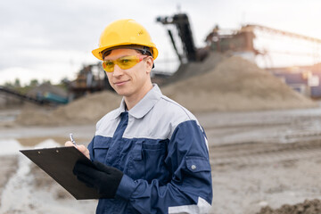 Portrait worker man surveying engineer in sand quarry and ore mining site