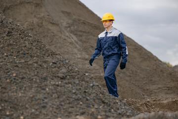 Caucasian engineer surveying in sand quarry and ore mine