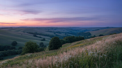 Beautiful golden hour panoramic landscape scene featuring rolling hills and colorful sunset skies.