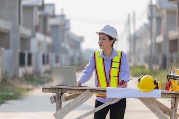 Caucasian construction manager monitors progress at a residential construction site