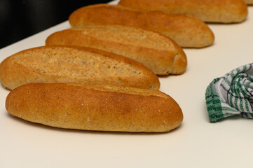 Rustic baguettes made from graham flour resting on a clean white table, showcasing artisanal baking and healthy ingredients.