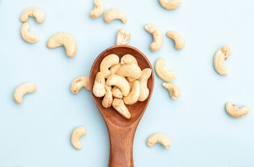 Top View of Cashew Nut in a Wooden Spoon Isolated on Light Blue Background with Copy Space, Healthy Eating Dry Fruit