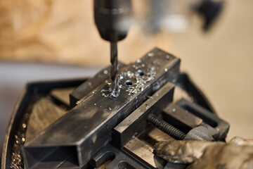Close-Up of Metalworking Drill Press Machining Metal Piece in Workshop