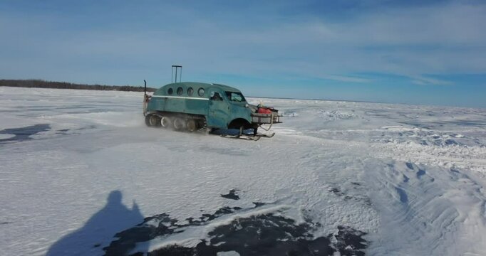 rescue team or group of fishermen in winter on frozen lake and ice with snowmobile going to save ice fisherman bobmbardier ski - doo 