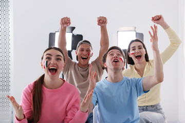 Emotional sports fans watching game together indoors