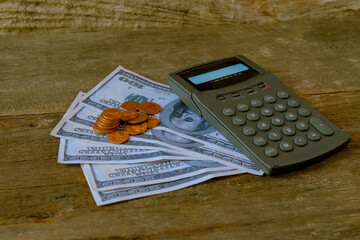 Calculator on US money and coins on table.