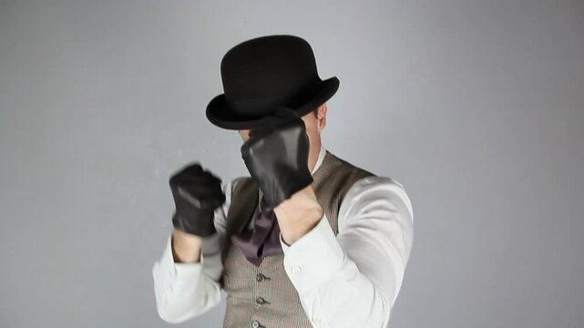 Vintage Ruffian or Back Alley Ruffian in Bowler Hat Pulling on Leather Gloves Ready to Fight