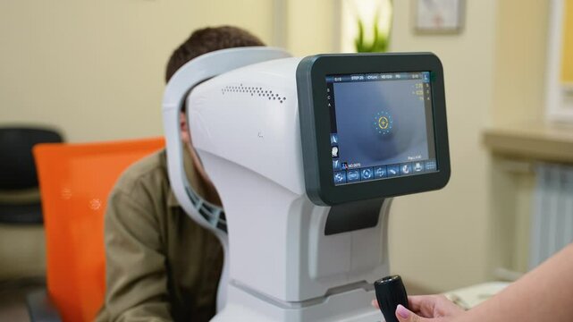 Optometrist examining patient's eye with autorefractor in ophthalmology clinic