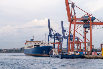 Bosphorus harbor with cargo ship and cranes during cloudy weather at dusk