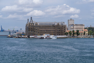 Fototapeta premium Bosphorus waterfront with restoration work on historical buildings and a ferry cruising in sunny weather