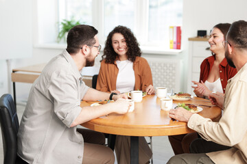 Colleagues chatting during lunch break in office