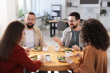 Colleagues chatting during lunch break in office