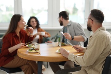 Colleagues chatting during lunch break in office