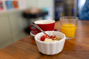 A healthy breakfast with muesli, fresh berries, orange juice and a cup of coffee.