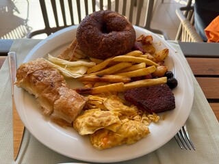 Unhealthy breakfast plate with bakeries, donuts and potatoes