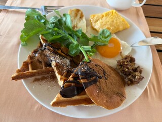 Pancake and waffle breakfast plate with egg and greens