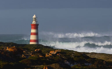 Lighthouse Standing Tall on a Scenic Hilltop Overlooking the Sea