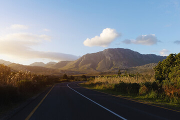 Sunset Country Road Leading to Distant Mountains on the Horizon