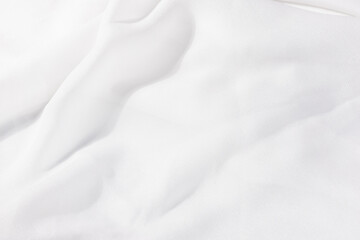Delicate white satin cloth with organic waves, used for backgrounds in fashion, beauty, or jewelry presentations.

