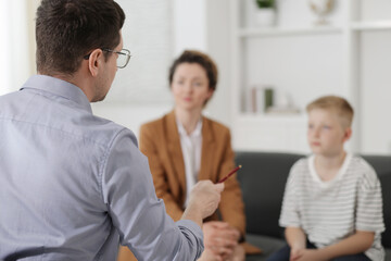 Mother and son having consultation with psychologist in office, selective focus