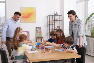 Fototapeta premium Kids with teachers at painting lesson indoors. Learning to draw