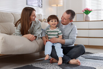 Fototapeta premium Cute little boy and his parents at home. Lovely family