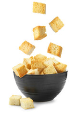Delicious crispy croutons falling into bowl on white background