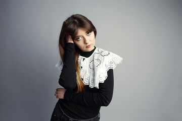 Thoughtful Young Woman with Hand in Hair, Posing in Studio