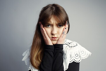 Pensive Young Woman Holding Face with Thoughtful Gaze