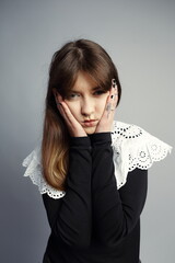 Pensive Young Woman Holding Face with Thoughtful Gaze